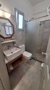 a bathroom with a sink and a toilet and a mirror at Paros Apartments in Parikia +54 photos