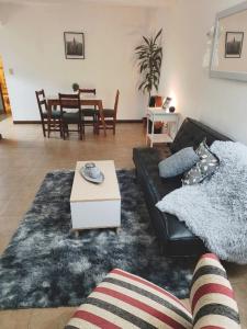 a living room with a black couch and a table at Mountain, espectacular departamento con vista súper funcional in Ushuaia