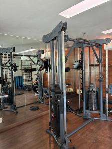 a gym with several tread machines and a mirror at Lake view in Brasília