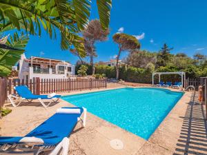 a swimming pool with lounge chairs and a volley ball at Sa Lluna by 3VILLAS in Binibeca