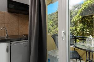 a kitchen with a view of a table and a balcony at Dimitreli Venetia Studios in Koinyra +26 photos