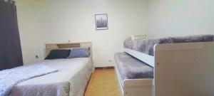 a bedroom with two beds and a couch in it at Mountain, espectacular departamento con vista súper funcional in Ushuaia