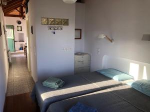 a bedroom with two twin beds and a hallway at To Ampeli in Potamós
