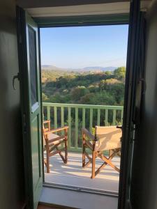 a door open to a balcony with a table and chairs at To Ampeli in Potamós +3 photos