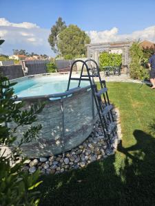 a swimming pool in a yard with rocks around it at Moradia Aura Santi in Esposende