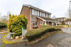 a brick house with a driveway in front of it at Rest & Nest in Chelsfield