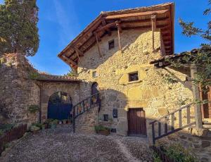 a large stone building with a wooden door and a staircase at LITTLE TOWER in Potes