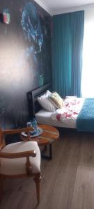 a room with two beds and a table and a chair at Butikowe pokoje in Głuchołazy