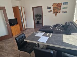 a living room with a table and a couch at Apartmány Vila Singles in Litoměřice