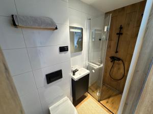 a white bathroom with a shower and a toilet at Butikowe pokoje in Głuchołazy