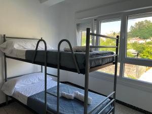 two bunk beds in a room with a window at pensión Palongo in Caldas de Reis