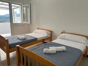 two beds with towels on them in a bedroom at pensión Palongo in Caldas de Reis