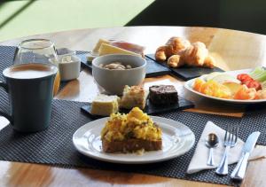 a table with plates of food and a cup of coffee at Hostería Verde Morada in Villa La Angostura +32 photos