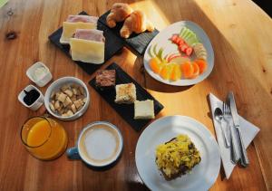 a wooden table with plates of food on it at Hostería Verde Morada in Villa La Angostura