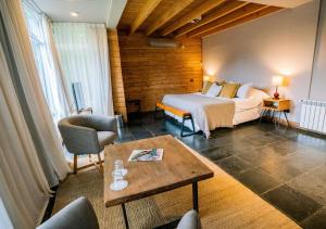 a hotel room with a bed and a table at Hostería Verde Morada in Villa La Angostura