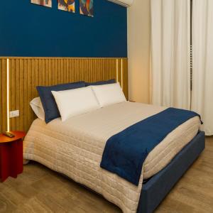a bedroom with a large bed with a blue wall at Prima Classe Battipaglia in Battipaglia