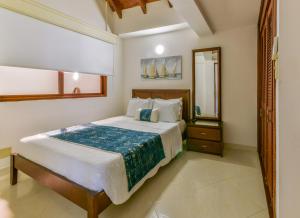 a bedroom with a large bed and a mirror at PENTHOUSE AGUAMARINA in San Andrés