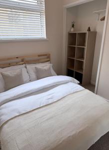 a bedroom with a large white bed with a window at Bungalow in Mumbles in The Mumbles