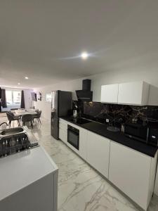 a kitchen with white cabinets and a table in a room at Le 21 Comfortable townhouse in Morhange +32 photos