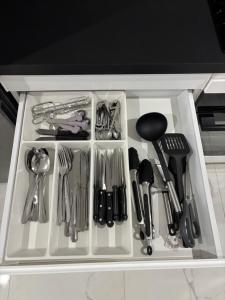 a white drawer filled with utensils on a counter at Le 21 Comfortable townhouse in Morhange