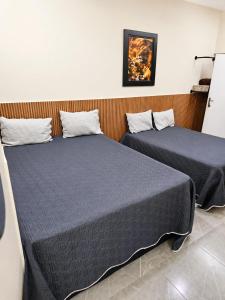 two beds sitting next to each other in a room at IMPERIAL BEACH ENSEADA 500 Metros Praia Enseada Gjá Av Professor João Batista Julião x Antonio Del Nero Enseadas jardim Virgínia Bairro Nobre in Guarujá