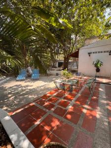 a patio with a table and chairs on a brick floor at Hotel Villa Ivel in Turbaco