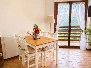 a dining room table with a vase of flowers on it at The Terrace Overlooking Lake Como in Muronico +16 photos