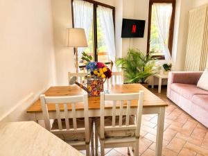a dining room table with a vase of flowers on it at The Terrace Overlooking Lake Como in Muronico