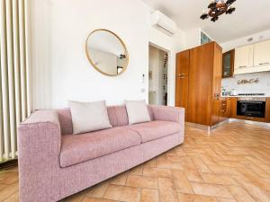 a living room with a pink couch and a mirror at The Terrace Overlooking Lake Como in Muronico