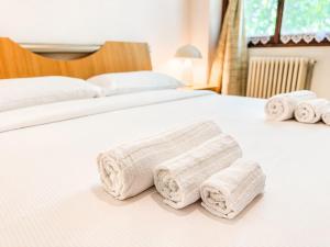 a white bed with towels on top of it at The Terrace Overlooking Lake Como in Muronico
