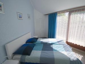 a bedroom with a bed and a window at Rustpunt in Brouwershaven