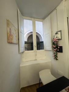 a room with a window with a chair and a table at Mare Fuori Apartment in Tropea
