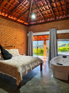 a bedroom with a bed and a bath tub at Solar do Ouro in São Thomé das Letras