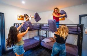 three girls are jumping on their bunk beds at The European House Pattaya in North Pattaya