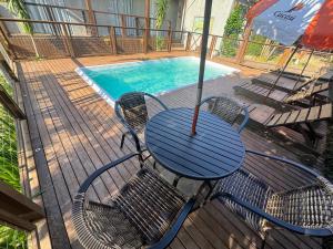 a table with an umbrella next to a swimming pool at Pousada Cacau in Praia do Rosa