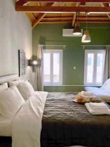 a bedroom with a large bed with white sheets at Iriki Loft, ένας ατμοσφαιρικός ρετρό χώρος στην Μυτιλήνη in Mytilene