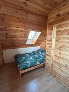 a bedroom in a log cabin with a bed in it at Dom Pod Niebem in Świętajno