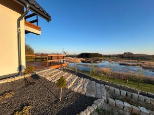 a house with a stone walkway next to a river at Dom Pod Niebem in Świętajno