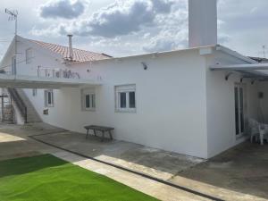 a white house with a green lawn in front of it at Refúgio Templário in Pedreira