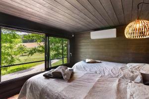 a bedroom with two beds and a large window at Cabane Spa-Truffiers-Proche Sarlat in Jayac +20 photos