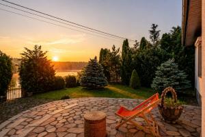 a couple of chairs sitting on a patio with the sunset at Ostoja Tobołowo in Tobołowo