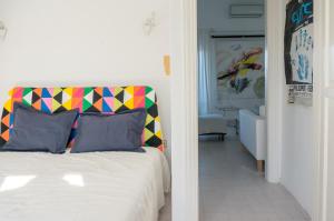 Schlafzimmer mit einem Bett mit farbenfrohem Kopfteil in der Unterkunft Blue Horizon 3 in Chalkidiki in Chaniotis