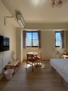 a bedroom with a bed and a table and a desk at 哈樓民宿二館 in Lukang