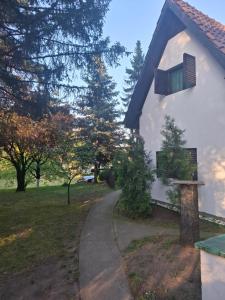 a white building with a window and a path at Šumska kuća Atina- Devojački Bunar in Alibunar