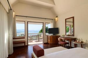 a bedroom with a bed and a view of a balcony at Centara Villas Phuket in Karon Beach