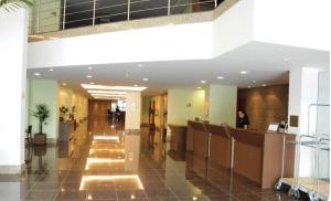 a lobby of a building with a woman standing at a counter at Flat Aconchegante Hotel Intercity Manaus in Manaus +22 photos