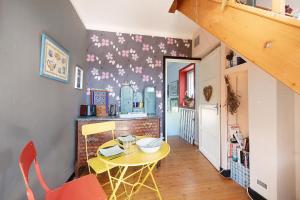 a kitchen with a yellow table in a room at Chez Fred proche plage et gr34 in Plougoulm