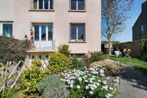 a house with a flower garden in front of it at Chez Fred proche plage et gr34 in Plougoulm