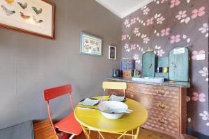 a yellow table and two chairs in a kitchen at Chez Fred proche plage et gr34 in Plougoulm