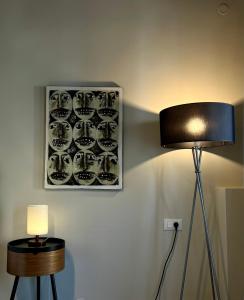 a lamp on a wall with a picture of cups at Iriki Loft, ένας ατμοσφαιρικός ρετρό χώρος στην Μυτιλήνη in Mytilene +29 photos